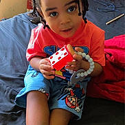 Kyrie joined the competition — help win amazing prizes! child, braided_hair, toy, bed, colorful_clothing, cartoon_characters, bracelet, indoors, smiling, young_child, person, bedroom, furniture, playtime, cute, crossed_legs, sitting, looking_up, happy, casual