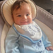 Jace joined the competition — help win amazing prizes! baby, infant, smile, onesie, bib, dinosaur, cushion, baby_seat, indoor, child, clothing, face, happy, cute, soft_lighting, young_child, portrait, relaxing, cozy, human