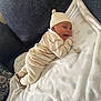 baby, blanket, child, comfortable, couch, cozy, cream_color, cute, furniture, happy, hat, indoors, infant, knitwear, lying_down, person, portrait, smiling, soft_texture, warm