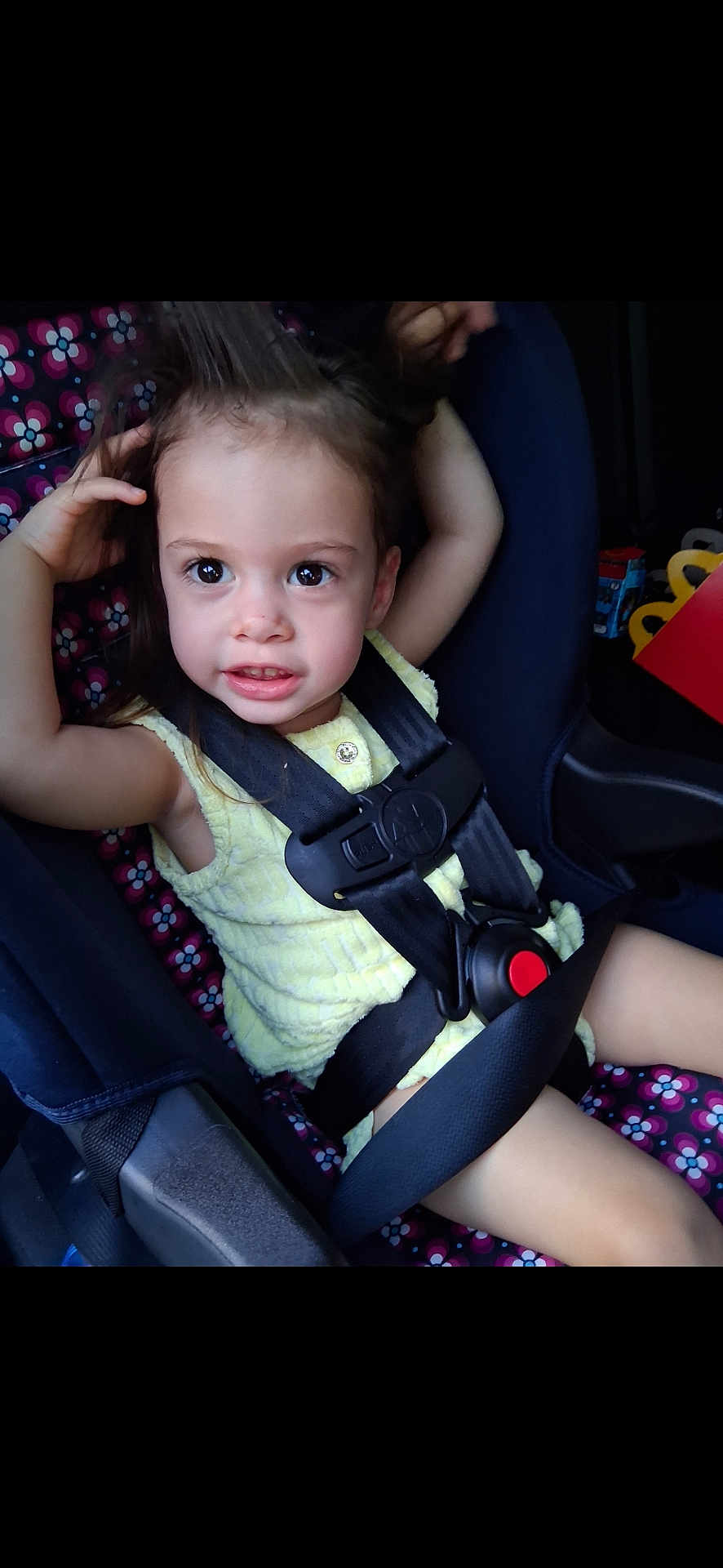 Alazae is registered to the contest to win money with this photo: toddler, child, car_seat, safety_harness, yellow_clothing, cute, playful, hair, big_eyes, car_interior, seatbelt, child_safety, portrait, smile, young_child, seat, colorful_pattern, happy, baby, person