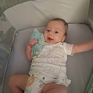 Taz joined the competition — help win amazing prizes! baby, infant, crib, plush_toy, smiling, diaper, onesie, child, bed, sleeping_area, cute, happy, hand, face, person, soft_toy, rest, lying_down, indoor, comfort