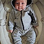 baby, infant, hoodie, clothing, socks, baby_seat, toy, soft_toy, indoor, portrait, child, cute, comfort, relaxing, person, face, eyes, expression, grey, casual