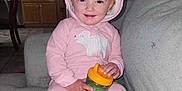 Amara is registered to the contest to win money with this photo: baby, bottle, clothing, couch, face, furniture, hat, head, hoodie, hosiery, indoors, knitwear, person, photography, portrait, shaker, sitting, sock, sweater, sweatshirt