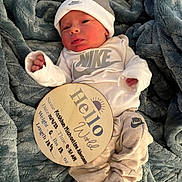 Kashton joined the competition — help win amazing prizes! newborn, baby, nike, hat, blanket, wooden_sign, birth_announcement, clothing, infant, cute, sleepy, portrait, indoor, soft_texture, lying_down, person, small_hands, baby_clothes, headwear, resting