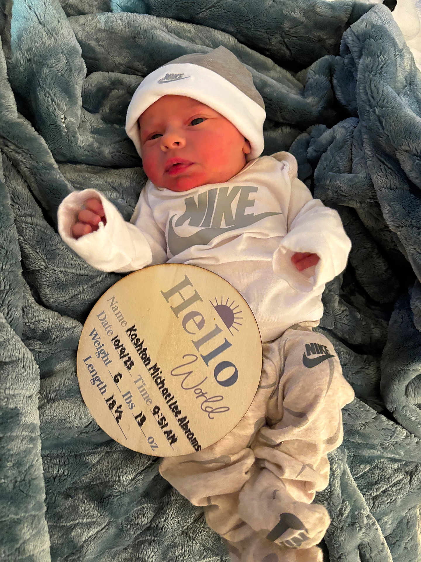 Kashton joined the competition — help win amazing prizes! newborn, baby, nike, hat, blanket, wooden_sign, birth_announcement, clothing, infant, cute, sleepy, portrait, indoor, soft_texture, lying_down, person, small_hands, baby_clothes, headwear, resting