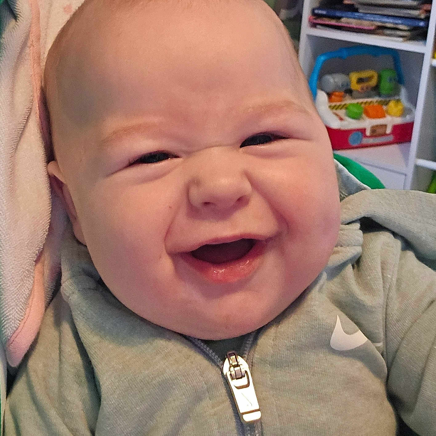 Karson joined the competition — help win amazing prizes! baby, smiling, face, hoodie, zipper, child, indoor, towel, happy, infant, person, clothing, toy, books, background, cute, expression, sitting, young, portrait