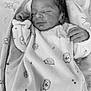 newborn, baby, sleeping, blanket, hedgehog_pattern, monochrome, soft, peaceful, infant, cute, wrapped, resting, child, bed, clothing, portrait, cozy, small_hands, face, relaxation