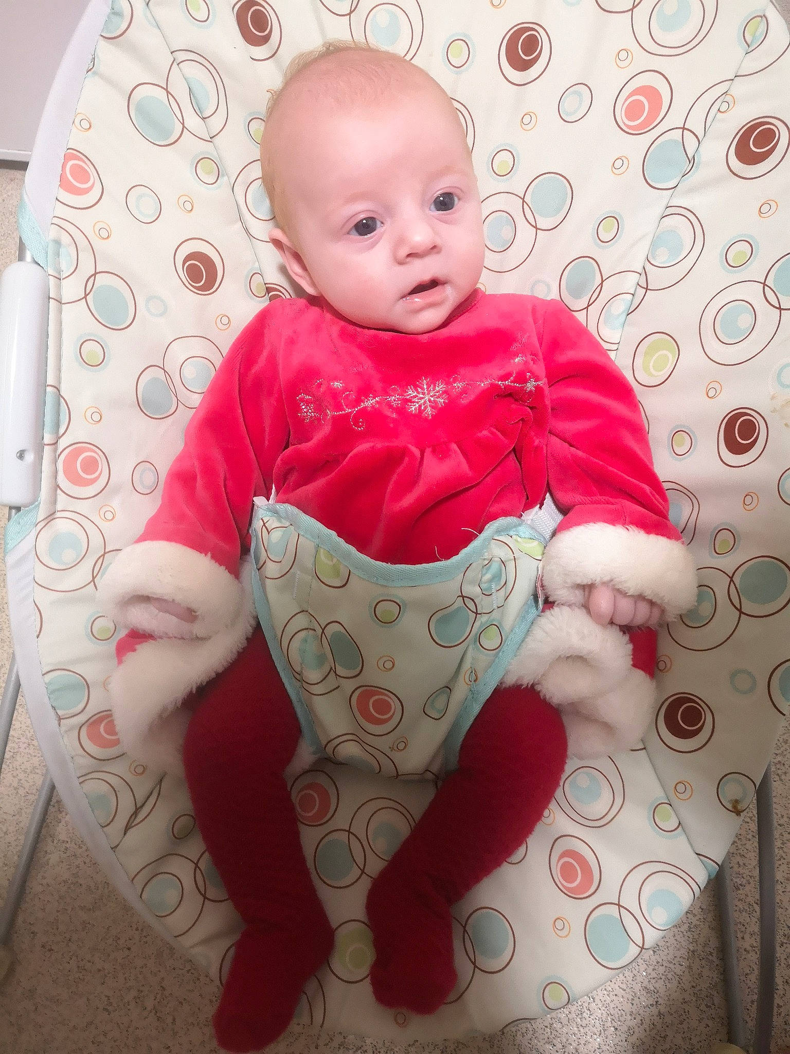 Emma is registered to the contest to win money with this photo: baby, baby_toddler_clothing, cheek, child, circle, comfort, face, flooring, happy, linens, magenta, mammal, pattern, person, pink, sitting, sleeve, smile, t_shirt, textile