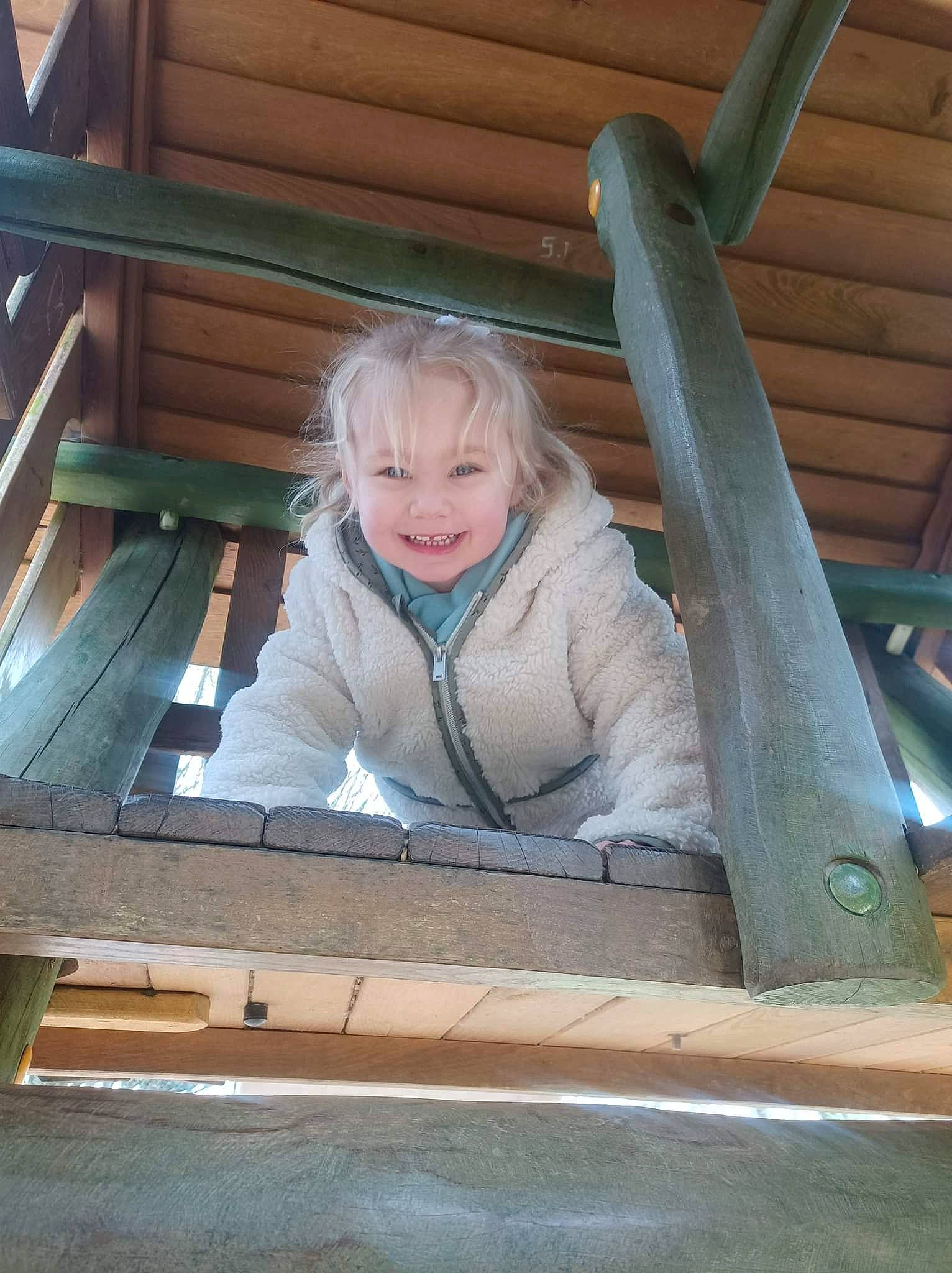 Ambre participe au concours pour gagner de l'argent avec cette photo : child, eye, face, fun, happy, hardwood, joy, leisure, outdoor_play_equipment, person, plank, product, recreation, rectangle, sitting, smile, standing, toddler, tree, window