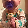 Delilah joined the competition — help win amazing prizes! baby, pacifier, onesie, turtle_pattern, hand, smiling, child, indoor, person, cute, infant, sleepwear, cozy, face, portrait, holding, happy, skin, small_hands, window