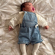 Giulia participe au concours pour gagner de l'argent avec cette photo : baby, infant, pacifier, denim_overalls, tights, bedspread, leaf_pattern, sleeping, child, cute, clothing, textile, soft_light, indoor, person, resting, newborn, peaceful, small_hands, cozy