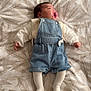 baby, infant, pacifier, denim_overalls, tights, bedspread, leaf_pattern, sleeping, child, cute, clothing, textile, soft_light, indoor, person, resting, newborn, peaceful, small_hands, cozy