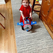 Asher joined the competition — help win amazing prizes! toddler, child, smiling, toy_airplane, ride_on_toy, red_clothing, indoor, hallway, rug, wood_floor, barstool, cabinet, furniture, portrait, playtime, happy, brown_hair, sitting, colorful_toy, home