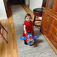 Asher joined the competition — help win amazing prizes! barstool, brown_hair, child, dresser, family_home, furniture, hallway, happy, home, indoor, playtime, portrait, red_outfit, rug, sitting, smiling, toddler, toy_airplane, toy_vehicle, wooden_floor