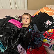 Kora is registered to the contest to win money with this photo: baby, bed, blanket, casual, child, clothes, colorful, comfort, curious, fabric, home, indoor, messy, pattern, person, pile, portrait, soft, textile, young