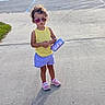 Kora joined the competition — help win amazing prizes! toddler, child, sunglasses, yellow_tank_top, purple_shorts, pink_sneakers, purse, sidewalk, outdoor, sunny, standing, fashion, curly_hair, concrete, casual_clothing, shadow, person, summer, cute, accessory
