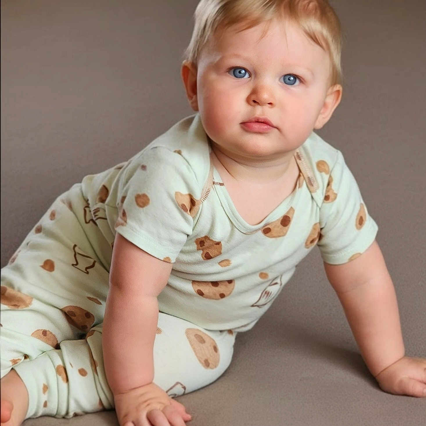 Kaynnan is registered to the contest to win money with this photo: baby, blue_eyes, child, chubby_cheeks, closeup, cookie_pattern, crawling, cute, feet, hands, indoor, infant, light_hair, looking_at_camera, pajamas, portrait, serious_expression, skin, soft_surface, young_child