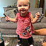 Lakelynne joined the competition — help win amazing prizes! toddler, child, smiling, standing, red_dress, minnie_mouse, shoes, living_room, couch, table, carpet, person, hand, happy, curly_hair, indoor, plaid, footwear, supporting_hand, furniture
