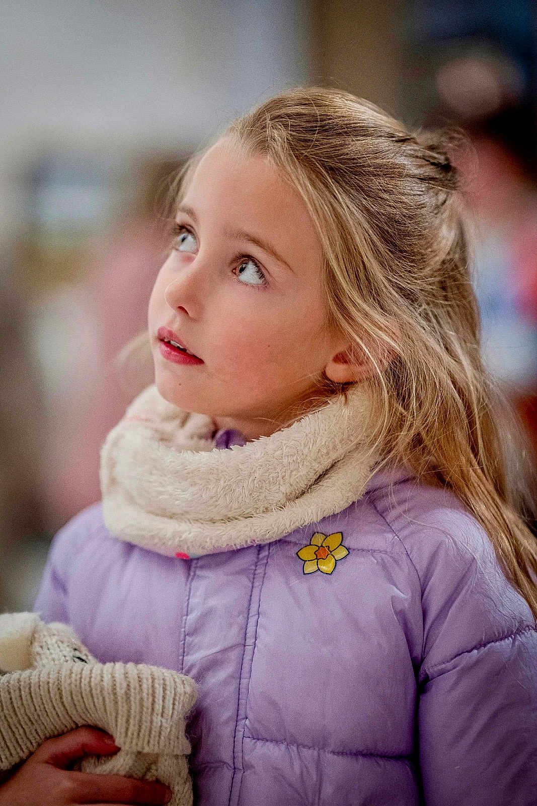 Clara a rejoint le concours — aidez-le/la à gagner de superbes lots ! child, girl, portrait, winter_clothing, jacket, scarf, knitted_item, blonde_hair, indoor, curious, face, person, young, warm_clothing, looking_up, casual, soft_lighting, pensive, cute, cozy