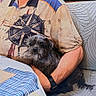 Dolly participe au concours pour gagner de l'argent avec cette photo : arm, calm, compass_design, couch, dog, elderly, glasses, holding, home, indoor, man, patterned_couch, pet, shirt, sitting, small_dog, striped_tablecloth, table, tablecloth, watch