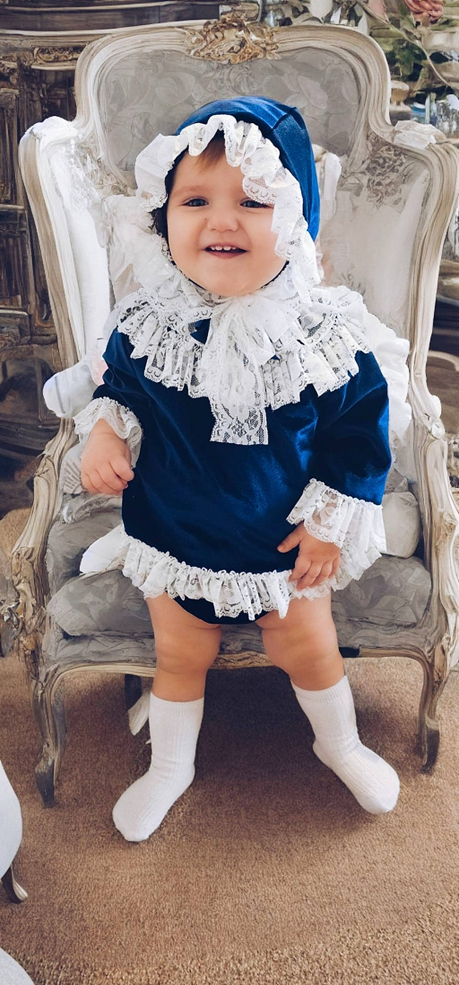 Sienna-Maria joined the competition — help win amazing prizes! baby, bonnet, cap, chair, clothing, costume, dress, face, footwear, furniture, hat, head, hosiery, pants, person, photography, portrait, shoe, sitting, sock