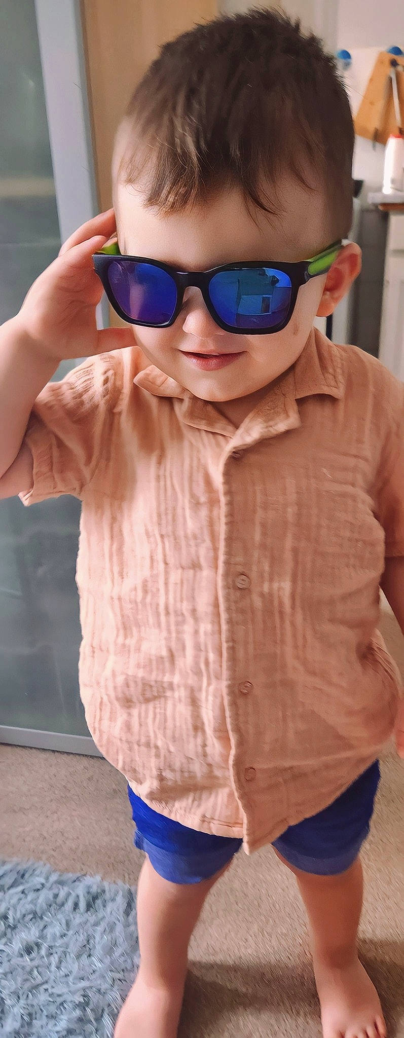 Sebastian is registered to the contest to win money with this photo: blue, cool, eyewear, fashion, finger, gesture, glasses, goggles, hand, lip, neck, outerwear, person, pink, shoulder, sleeve, smile, standing, sunglasses, vision_care