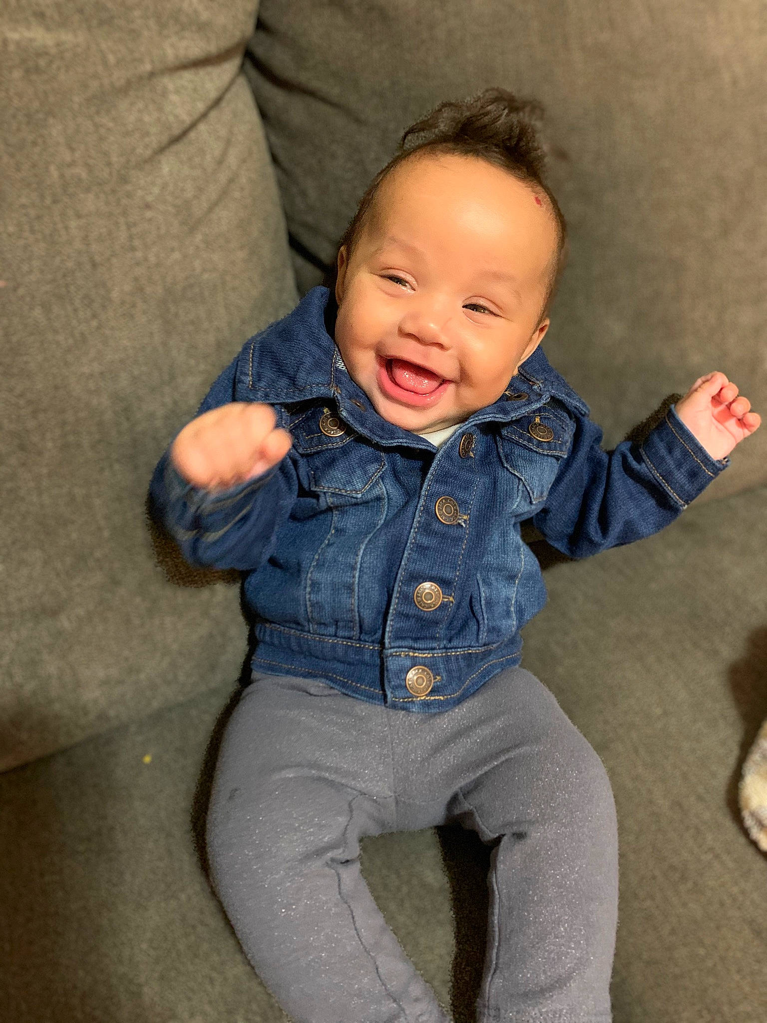 Hera is registered to the contest to win money with this photo: arm, baby_toddler_clothing, cheek, chin, eye, face, facial_expression, hair, hand, head, human_body, jeans, joy, leg, lip, mouth, neck, nose, person, shoulder