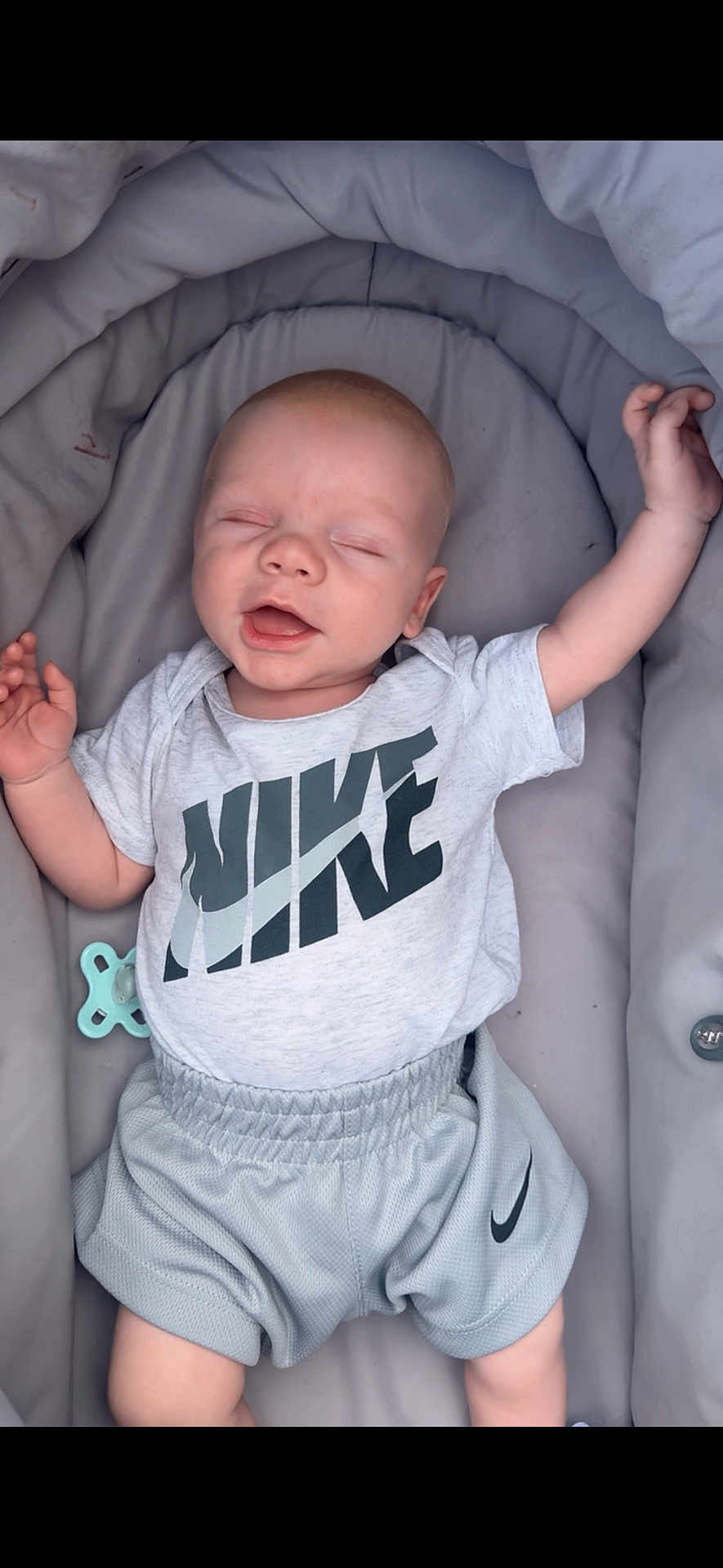 Teddie joined the competition — help win amazing prizes! baby, infant, smiling, sleeping, nike, clothing, shorts, tshirt, pacifier, cushion, carrier, comfort, relaxation, child, person, happy, cute, portrait, indoors, young