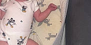 Teddie is registered to the contest to win money with this photo: baby, sleeping, onesie, mickey_mouse, bassinet, blanket, fox_pattern, mesh_sides, infant, cute, peaceful, indoor, child, resting, newborn, soft_lighting, fabric, legs, arms, face