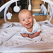 Enzo participe au concours pour gagner de l'argent avec cette photo : baby, smiling, happy, infant, play_mat, baby_gym, toy, indoor, floor, towel, cute, child, person, head, eyes, mouth, skin, clothing, home, playtime