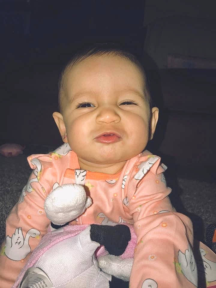 Isabella is registered to the contest to win money with this photo: baby, cheek, child, eye, face, finger, fun, happy, mouth, person, skin, smile, tableware, thumb, toddler