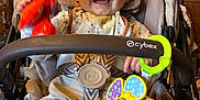 Liam a rejoint le concours — aidez-le/la à gagner de superbes lots ! baby, child, clothing, colorful, face, furniture, happy, indoor, infant, people, person, playful, rattle, restaurant, seatbelt, seated, smiling, socks, stroller, toy