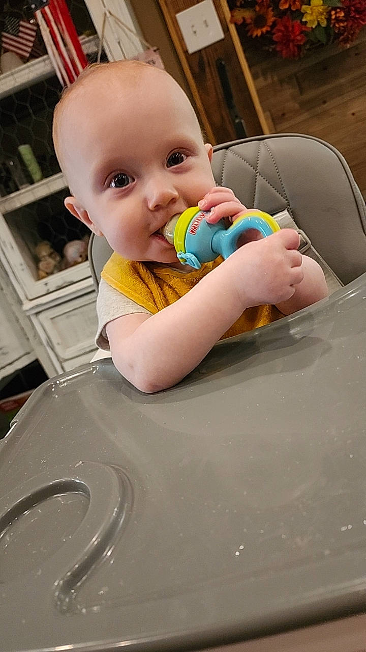 Stedson joined the competition — help win amazing prizes! baby, cabinet, chewing, child, cute, decor, expression, face, furniture, happy, high_chair, home, indoor, infant, person, seated, smile, toy, wood, yellow_bib