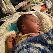 Kingston Hicks is registered to the contest to win money with this photo: baby, newborn, sleeping, blanket, pacifier, infant, cozy, clothing, hand, face, bed, comfort, soft, rest, child, indoor, cute, peaceful, toddler, furniture