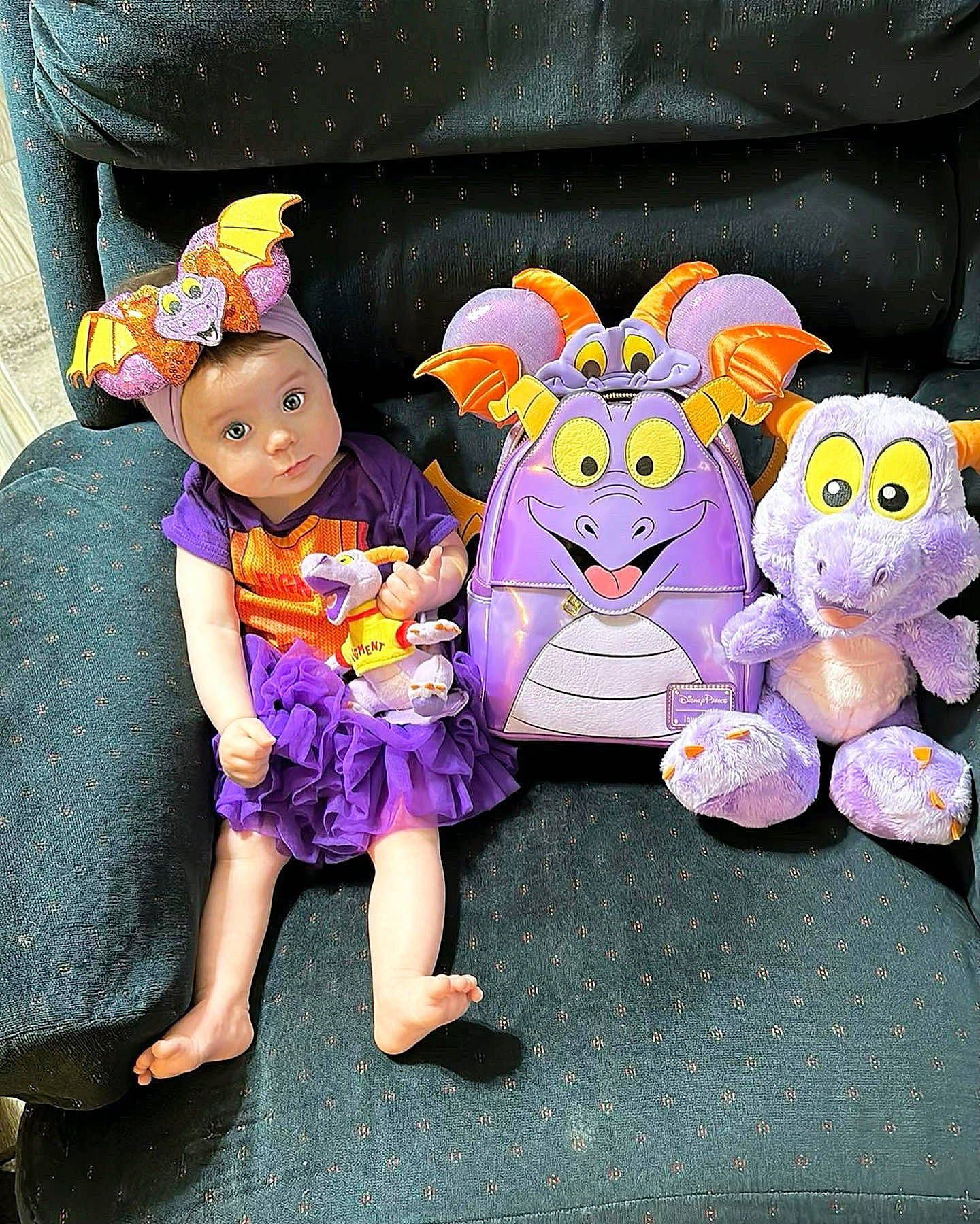 Alice is registered to the contest to win money with this photo: baby_toddler_clothing, child, costume, doll, event, fictional_character, fun, happy, hat, headwear, magenta, party_supply, person, petal, pink, plush, purple, sitting, stuffed_toy, toddler