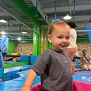 Tyler is registered to the contest to win money with this photo: active, casual_clothing, child, climbing_wall, colorful, family, fun, happy, indoor, leisure, padded_mats, people, person, play_area, playground, recreation, short_sleeves, smiling, toddler, young_child