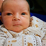 Tyler participe au concours pour gagner de l'argent avec cette photo : baby, infant, onesie, clothing, patterned_clothing, face, eyes, hand, blanket, soft_texture, indoor, newborn, cute, portrait, person, child, warm, cozy, serious_expression, closeup