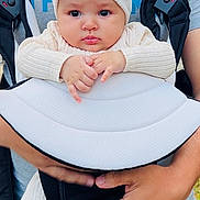 Melissa Léa participe au concours pour gagner de l'argent avec cette photo : baby, child, infant, baby_carrier, headband, bow, hands, clothing, adult, person, outdoor, green_pants, gray_shirt, holding, cute, face, expression, closeup, portrait, human
