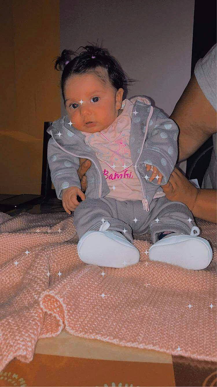 Yvannah participe au concours pour gagner de l'argent avec cette photo : arm, baby, baby_toddler_clothing, carmine, cheek, child, comfort, flooring, foot, fun, hoodie, knee, lap, leg, person, sitting, skin, sleeve, t_shirt, thigh