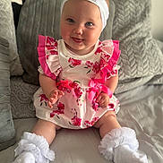 Ivyjane joined the competition — help win amazing prizes! baby, child, smiling, dress, floral, headband, bow, socks, frills, pillow, bed, indoor, cute, infant, person, portrait, happy, sitting, soft, cozy