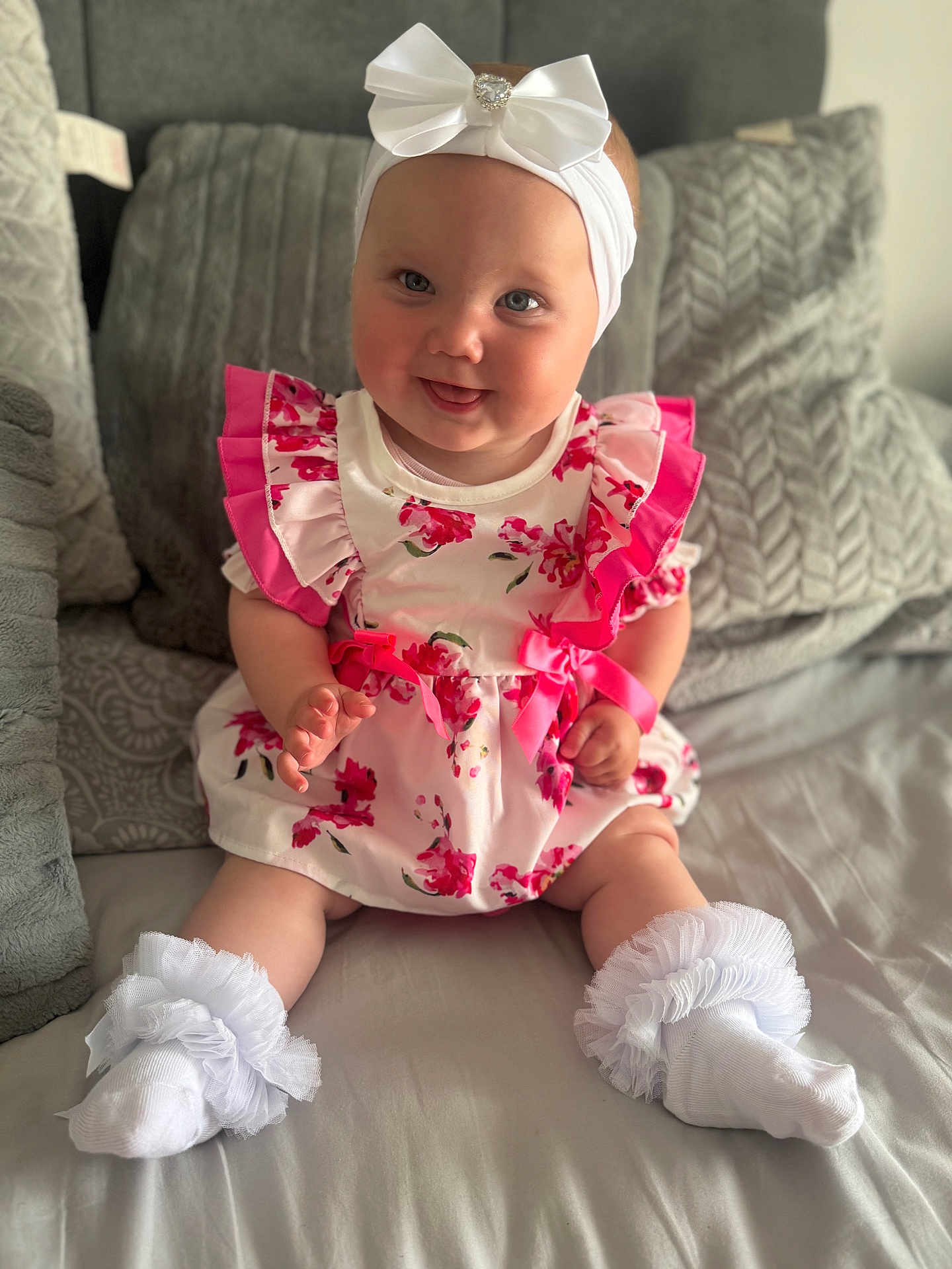 Ivyjane joined the competition — help win amazing prizes! baby, child, smiling, dress, floral, headband, bow, socks, frills, pillow, bed, indoor, cute, infant, person, portrait, happy, sitting, soft, cozy