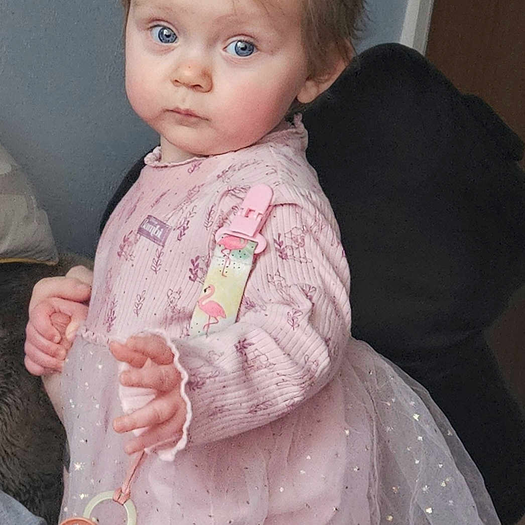 Luna is registered to the contest to win money with this photo: accessories, baby, bodypart, car, clothing, coat, couch, dress, face, finger, furniture, hand, head, jacket, person, photography, portrait, sitting, transportation, vehicle