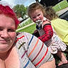 Isabelle is registered to the contest to win money with this photo: arm_cast, casual_clothing, child, children, daylight, family, fence, grass, greenery, outdoor, pacifier, playful, portrait, red_hair, smile, sunny, tattoo, vehicle, watch, woman