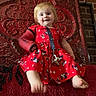 baby, brick_wall, carpet, cast, child, cute, decorative_panel, happy, home_interior, indoor, mickey_mouse, pacifier, playful, portrait, red_cushion, red_dress, sitting, smile, toddler, young_child
