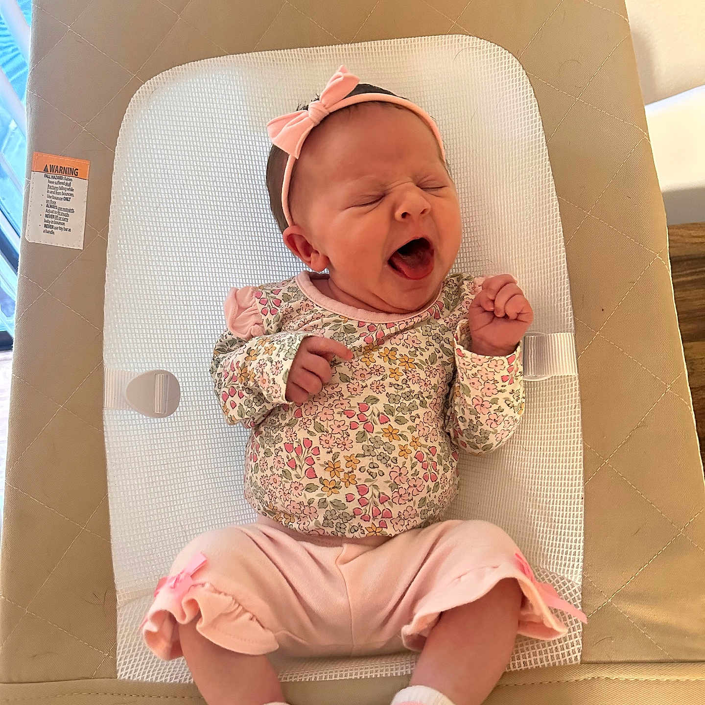 Caecilia is registered to the contest to win money with this photo: baby, baby_seat, child, comfort, cushion, cute, fabric, floral_pattern, headband, indoors, infant, newborn, person, pink_clothing, relaxing, resting, sleepy, socks, soft_lighting, yawning