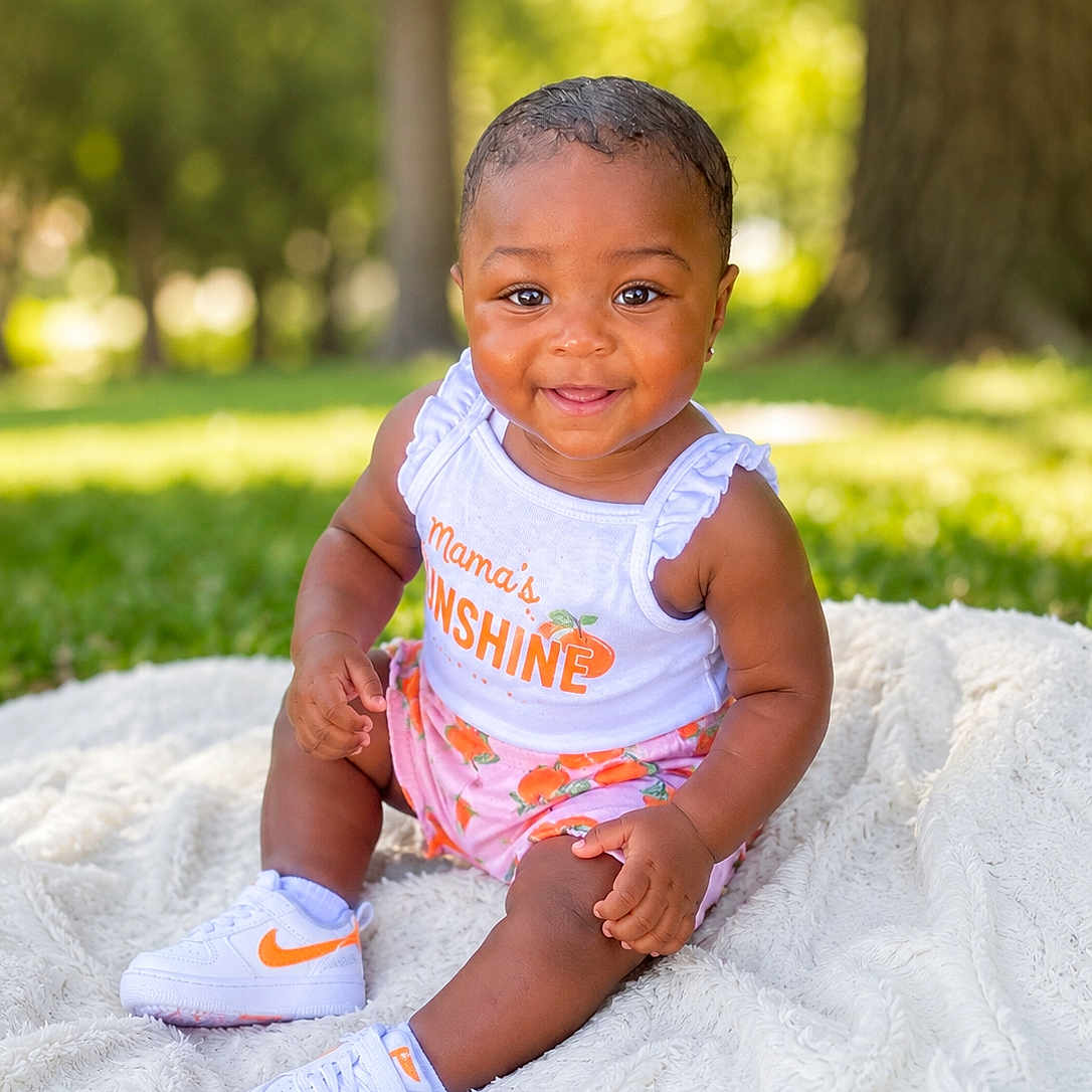 Stacee is registered to the contest to win money with this photo: baby, child, smiling, outdoor, grass, blanket, clothing, shoes, sitting, cute, sunlight, portrait, happy, infant, toddler, nature, greenery, face, fashion, summer