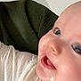 Lina participe au concours pour gagner de l'argent avec cette photo : baby, close_up, smiling, face, child, infant, white_shirt, fruit_design, joyful, happy, skin, eyes, cheeks, mouth, texture, green_background, person, portrait, cute, expression