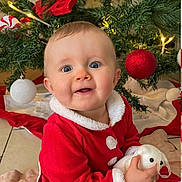 Lina participe au concours pour gagner de l'argent avec cette photo : baby, celebration, child, christmas_ball, christmas_tree, cute, decoration, face, festive, happy, holiday, holiday_lights, indoors, ornament, person, plush_toy, red_clothing, seasonal, sitting, smile