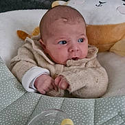 Alva participe au concours pour gagner de l'argent avec cette photo : baby, infant, sweater, plush_toy, cushion, quilt, bead_toy, face, hands, cozy, indoor, child, soft_toys, curious, seated, closeup, cute, expression, blanket, comfort