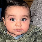 Emirhan participe au concours pour gagner de l'argent avec cette photo : baby, child, face, eyes, jacket, green, fuzzy, portrait, indoor, curious, young, cute, infant, closeup, person, clothing, warm, expression, head, skin